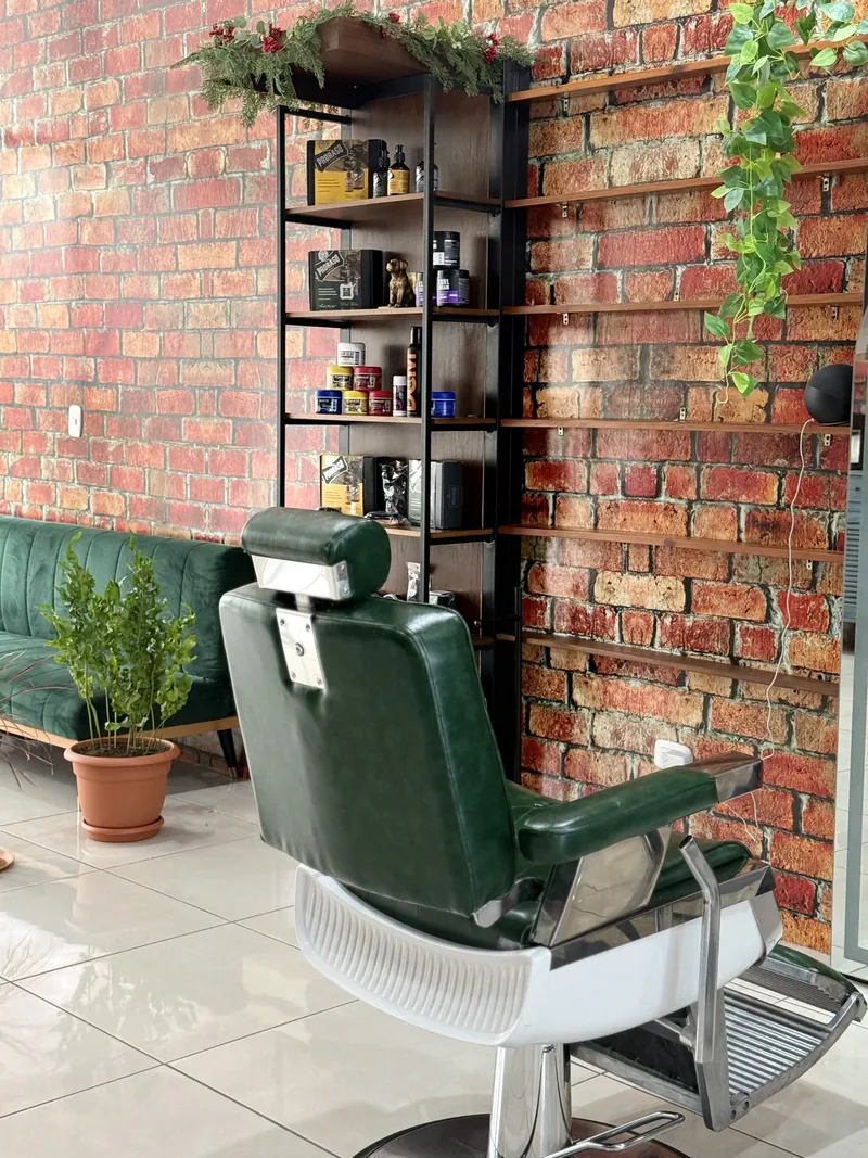 Repisa con productos de cuido junto a una silla de barbero en Garten Barberclub